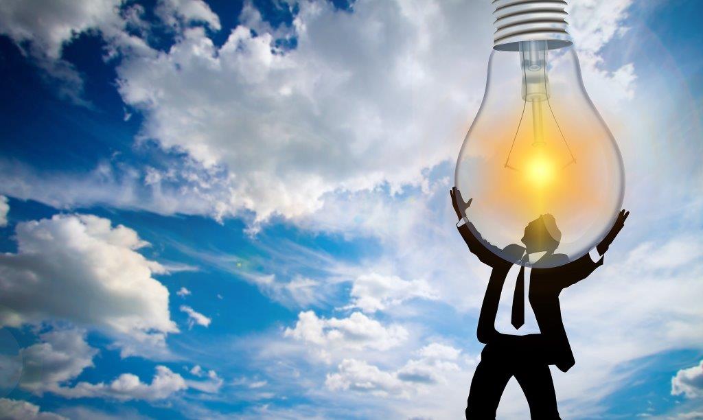 man holding big light bulb with sky and clouds background