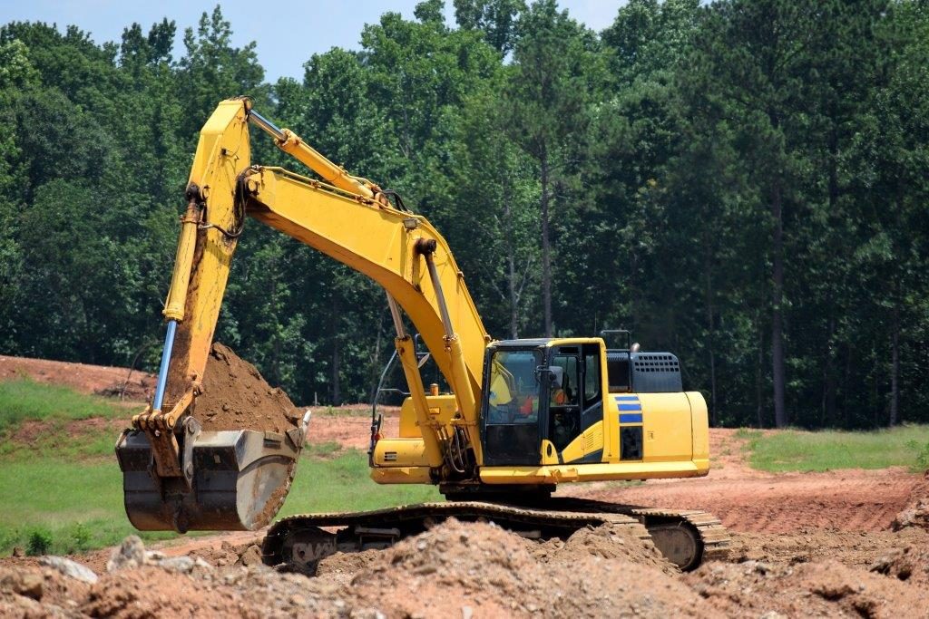 And excavator lifting sand with excavator insurance